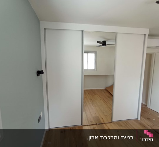 ארון עם דלתות הזזה ומראה בחדר שינה